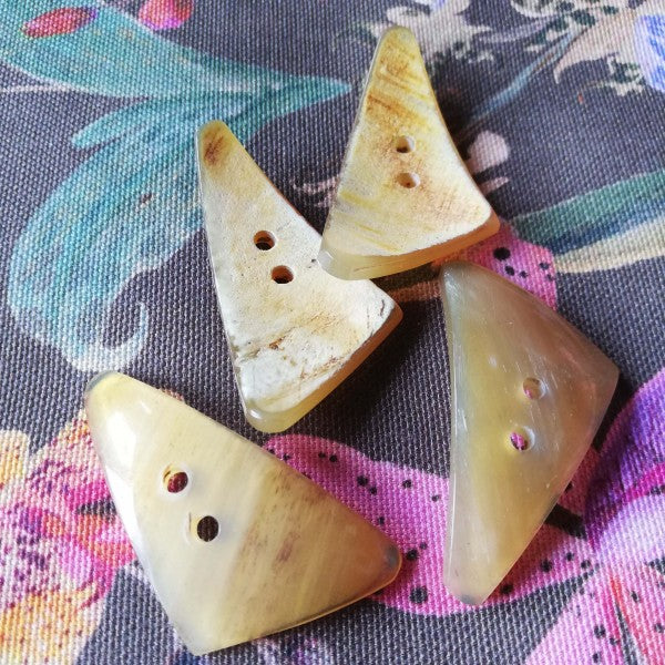 Natural button made of horn in natural colors slightly transparent