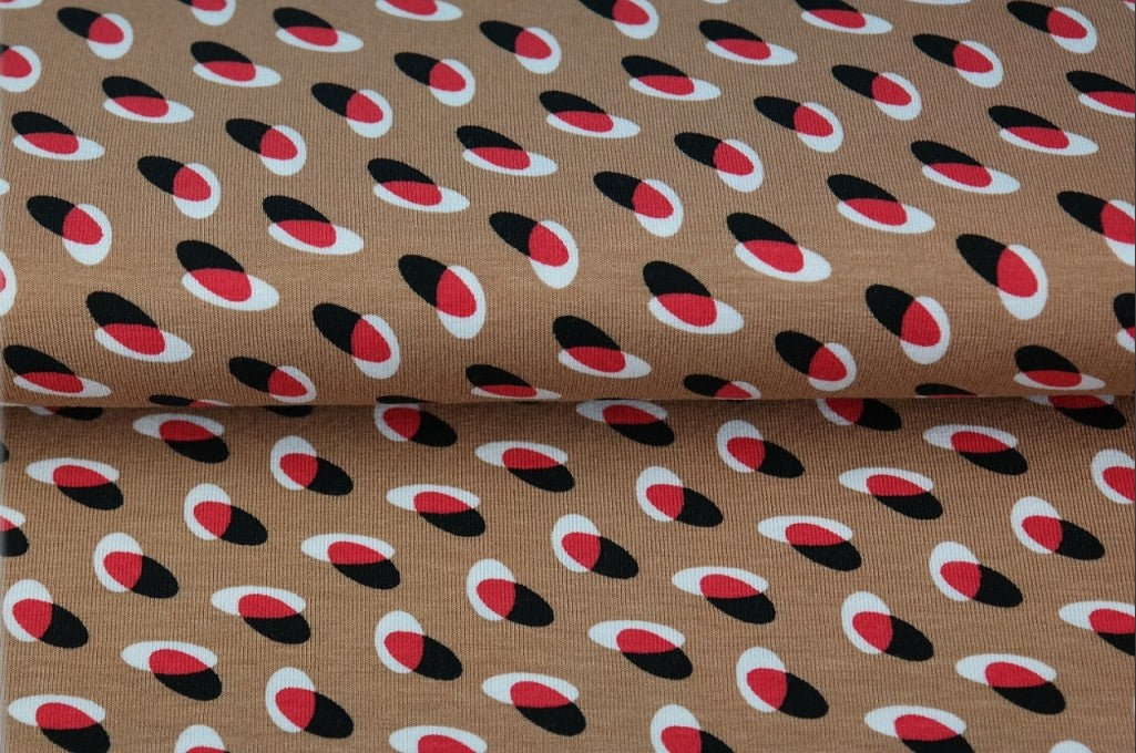 Jersey viscose couleur nougat avec cercles superposés rouges, blancs et noirs 